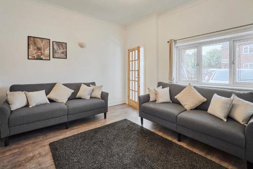 una sala de estar con 2 sofás y una ventana en Host & Stay - Church Street, en Golborne