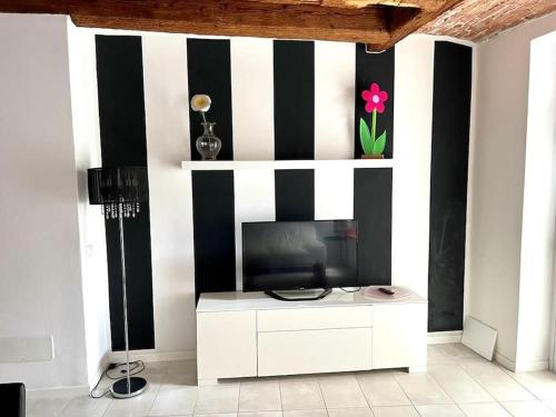 sala de estar con TV y rayas en blanco y negro en Garden House Soave en Soave