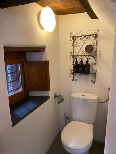 a bathroom with a white toilet and a window at Iconic Italian Townhouse w Rooftop Terrace & Mountain View, Pigna in Pigna