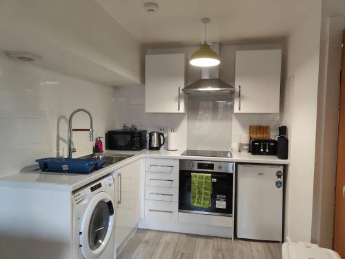 a kitchen with a washing machine and a washer at Drummond Condo in Edinburgh