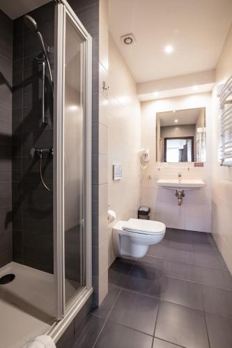 a bathroom with a toilet and a sink and a shower at Hotel Maraton in Bydgoszcz