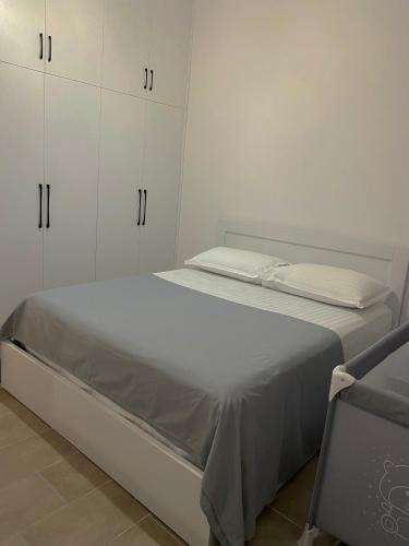 um quarto branco com uma cama e armários brancos em Luxury Durres Apartament Sea View em Durrës