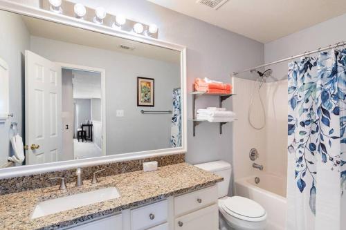 y baño con lavabo, aseo y espejo. en 4Bedroom Rockwall Getaway, en Rockwall