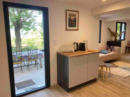 Apartament obejmuje kuchnię z blatem oraz salon z patio. w obiekcie Maison les Acacias w mieście Millau