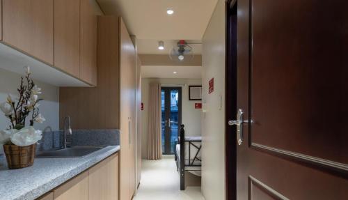 a kitchen with a sink and a door to a hallway at Marvelle Studios in Manila