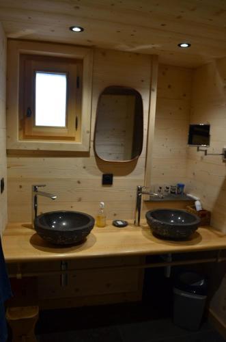 une salle de bain avec deux lavabos et un miroir dans l'établissement Appartement Les Greniers Châtel Réservation, à Châtel