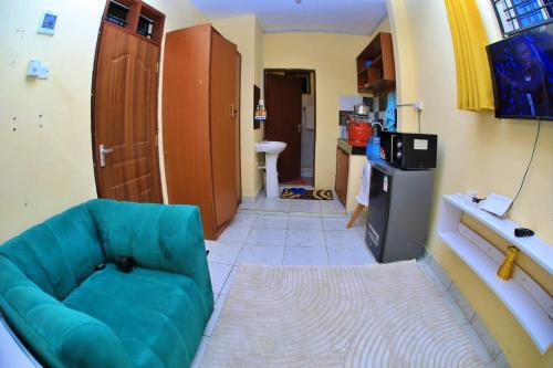 a living room with a blue couch and a television at Lux Suites Ratna Studio Apartments in Nyali