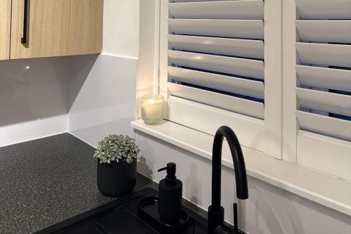 a kitchen with a sink and a candle on a counter at Cosy 1BD Getaway Perfect for Couples Stamford in Stamford