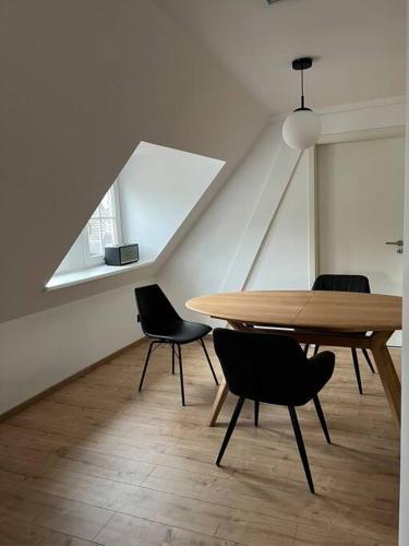 une salle à manger avec une table et des chaises en bois dans l'établissement LE DONJON Classé 4 étoiles Appartement 120 m2 5mn Centre Ville Au Calme, à Strasbourg