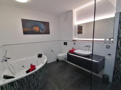a bathroom with a tub and a toilet and a sink at FeWo Excellence Juwel in Cochem