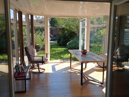 a screened in porch with a table and two chairs at 32 Station Road in Higham on the Hill