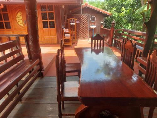 a wooden table and chairs on a patio at Duangmanee homestay 