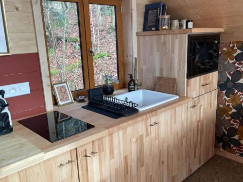 - une cuisine avec un grand évier blanc dans l'établissement Casa Slow avec sa piscine chauffée au bord du lac, à Les Croix Chemins