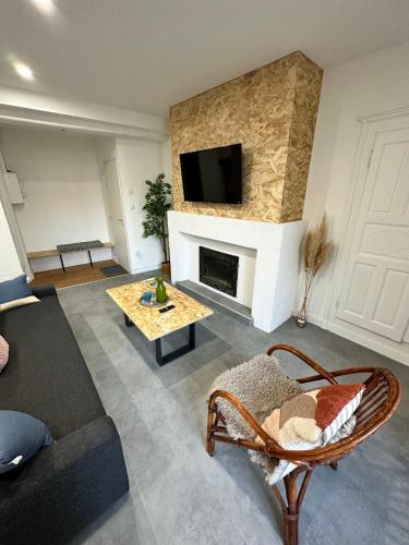 un salon avec un canapé et une cheminée dans l'établissement Appartement T3 cosy et moderne, à Baugé