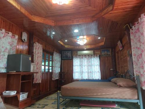 ein Schlafzimmer mit einem Bett in einem Holzzimmer in der Unterkunft Duangmanee homestay 