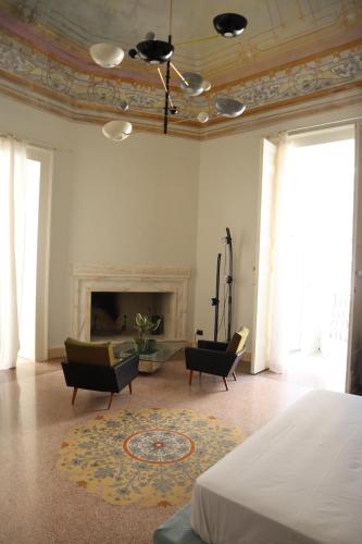 a room with a bed and chairs and a fireplace at Roiss Haus Suites in Lecce