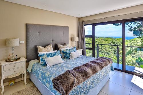 a bedroom with a bed and a large window at Holiday home in Zimbali in Ballito