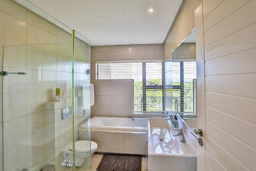 ein Badezimmer mit einer Badewanne, einem WC und einem Waschbecken in der Unterkunft Holiday home in Zimbali in Ballito