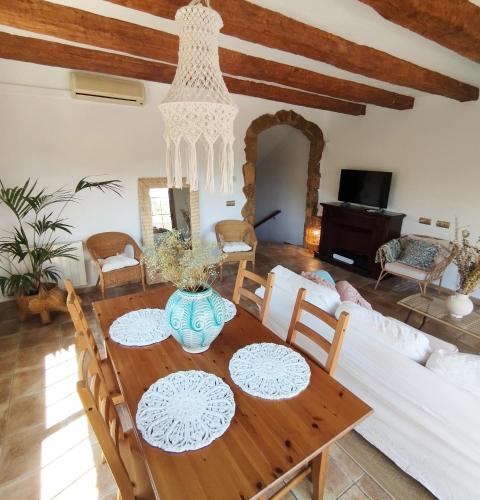 a dining room with a wooden table and a couch at AMIRA home near Sitges in Sant Pere de Ribes