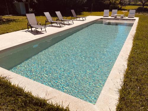 a swimming pool with lounge chairs and a pool of water at Quinta Tilia - Farmhouse in Oliveira de Azemeis