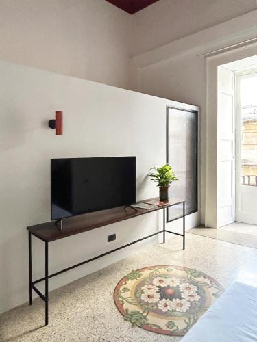 a living room with a flat screen tv on a wall at Roiss Haus Suites in Lecce