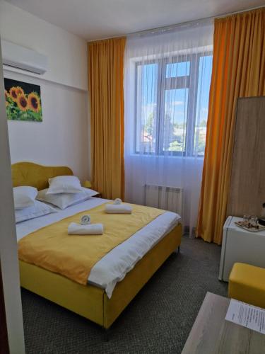 sypialnia z dużym łóżkiem z dwoma ręcznikami w obiekcie ANTIK HOUSE w mieście Cornu de Jos