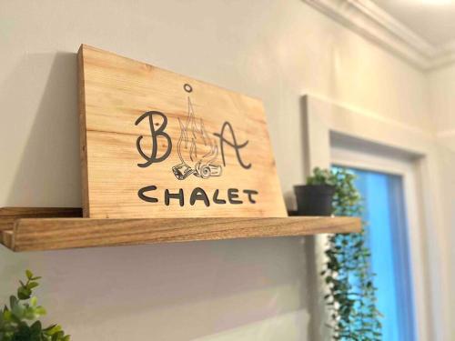 a wooden sign that reads shaker sitting on a shelf at Chalet BIA - Au courant des 2 rivières in Weedon-Centre