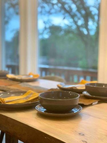 a wooden table with bowls and plates on it at Chalet BIA - Au courant des 2 rivières in Weedon-Centre
