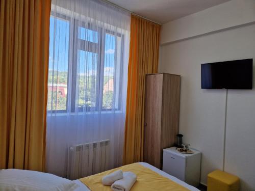 a hotel room with a bed and a window at ANTIK HOUSE in Cornu de Jos