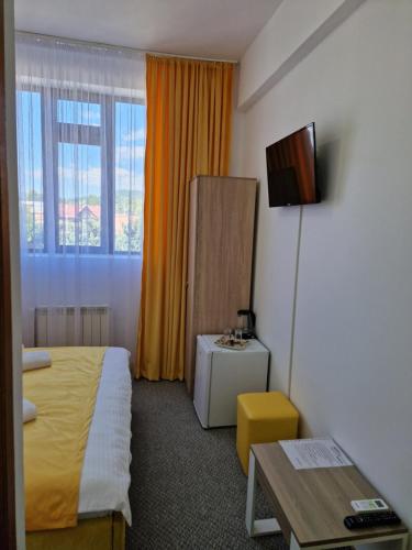 a hotel room with a bed and a table at ANTIK HOUSE in Cornu de Jos
