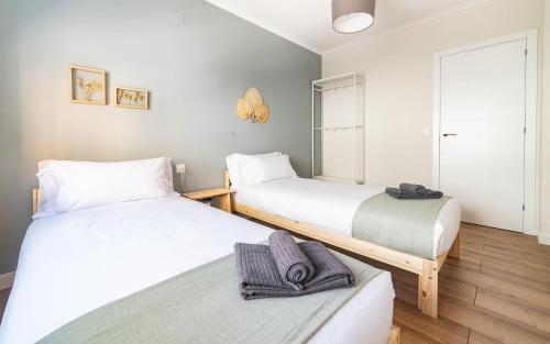 a bedroom with two beds and a window at Apartamento Plaza da Gándara in Narón