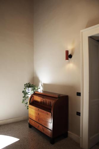 a wooden organ in a corner of a room with a plant at Roiss Haus Suites in Lecce