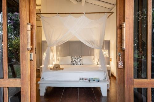 a bedroom with a bed with a canopy at Pousada Denada in Barra Grande