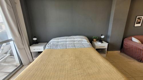 1 dormitorio pequeño con 1 cama y 2 mesitas de noche en La vista, departamento cómodo y acogedor en Salta