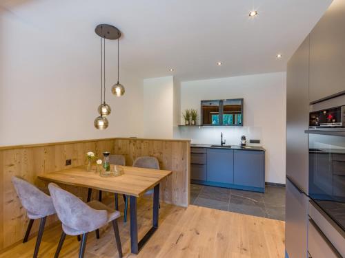 a kitchen with a wooden table and chairs at Das Bergjuwel in Auffach