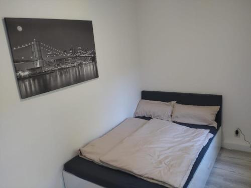 a bed in a room with a picture on the wall at fewo-Grychnik in Dresden