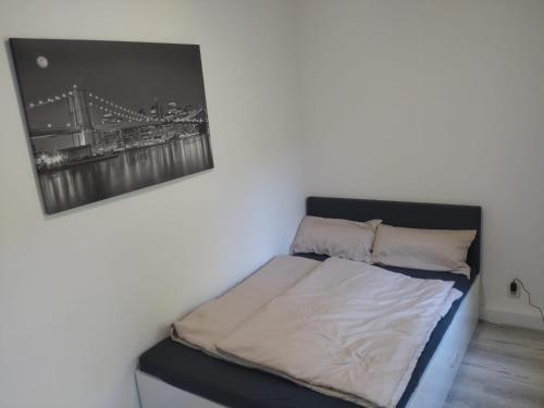 una cama en una habitación con un cuadro en la pared en fewo-Grychnik, en Dresden