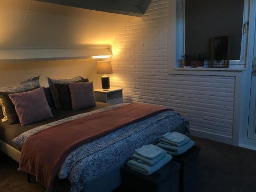 een slaapkamer met een bed met handdoeken erop bij Hei-d-Away in Otterlo