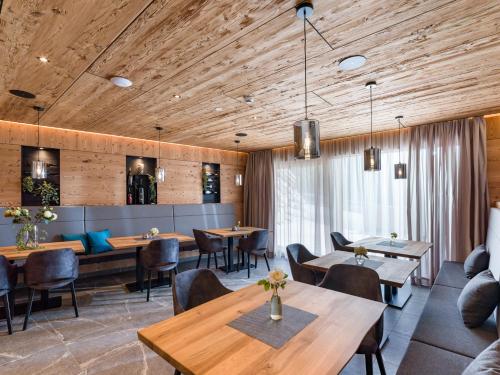 アウフファッハにあるDas Bergjuwelの木製の天井、テーブルと椅子のあるレストラン
