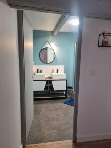 een badkamer met 2 wastafels en een spiegel bij APPARTEMENT COSY 