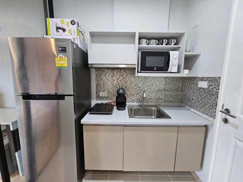 eine kleine Küche mit Kühlschrank und Spüle in der Unterkunft Zcape1 Condo Bangtao Beach in Ban Thalat Choeng Thale