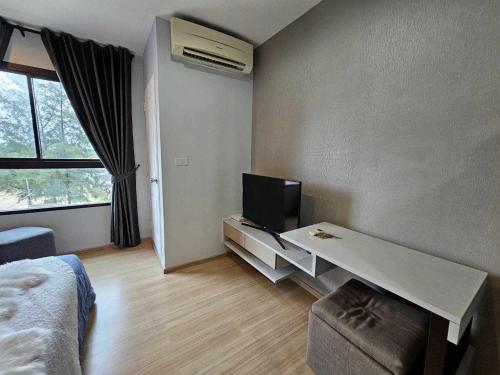 Zimmer mit einem Bett und einem Schreibtisch mit einem TV in der Unterkunft Zcape1 Condo Bangtao Beach in Ban Thalat Choeng Thale