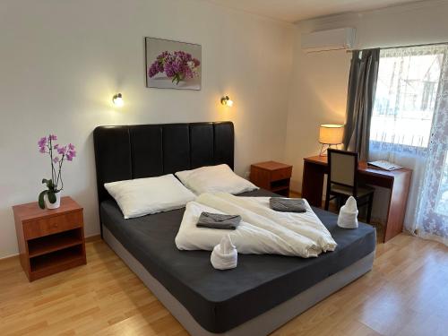 een slaapkamer met een bed met een zwart hoofdeinde bij Boni Családi Wellness Hotel in Zalakaros