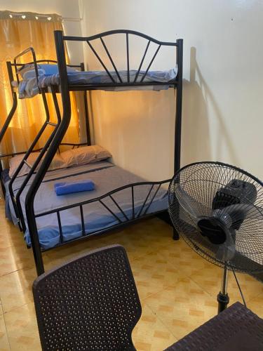 a room with two bunk beds and a fan at Bagobantay hostel in Manila