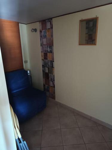a room with a blue chair next to a wall at affitta camere Rosa Tea in Nocera Inferiore