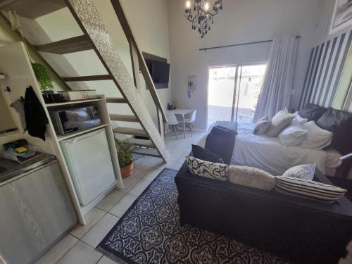 ein Schlafzimmer mit einem Bett, einem Sofa und einem TV in der Unterkunft Angel 8 AirBnB Apartment 2 in Robertson