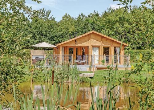 a wooden cabin in the middle of a pond at The Windsor Lodge in Ellesmere