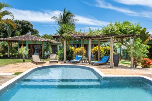 a swimming pool with chairs and a gazebo at Pousada Denada in Barra Grande