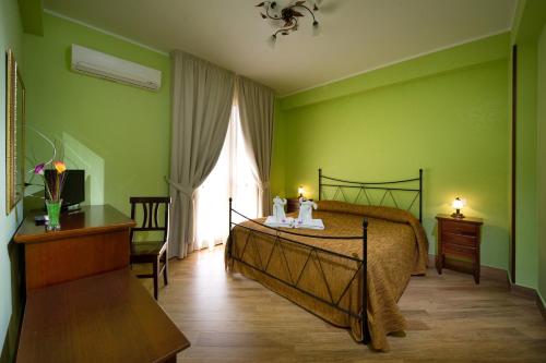 een groene slaapkamer met een bed en een raam bij Al Cantuccio in Castelluzzo