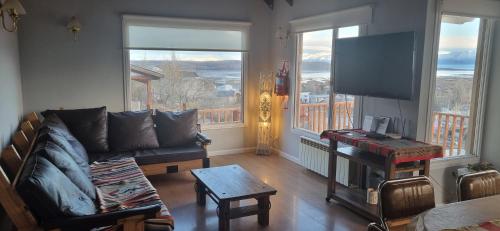 a living room with a couch and a flat screen tv at Casa Franca in El Calafate